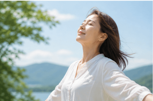 시원한 바람을 맞으며 미소 짓는 중년 여성의 편안하고 희망적인 모습